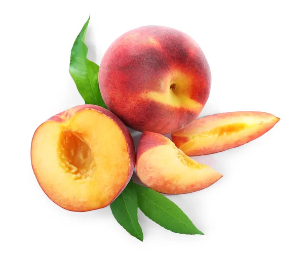 Süße saftige Pfirsiche mit Blättern auf weißem Hintergrund, Ansicht von oben — Stockfoto