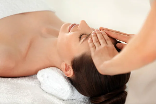 Beautiful young woman enjoying massage in spa salon — Stock Photo, Image