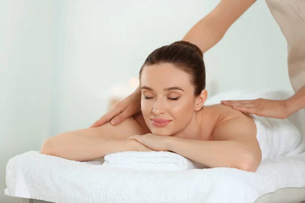 Bella giovane donna che gode di un massaggio nel salone spa — Foto Stock