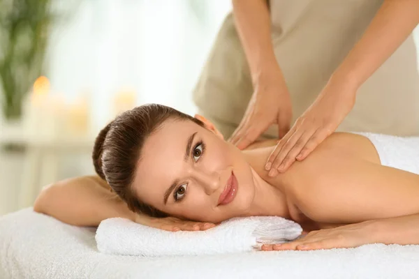 Beautiful young woman enjoying massage in spa salon — Stock Photo, Image