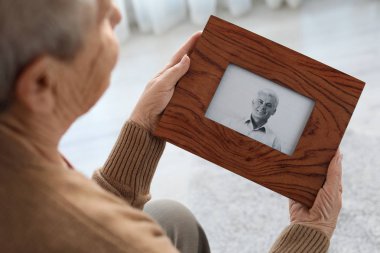 Evde oğlunun çerçeveli fotoğrafı ile yaşlı kadın