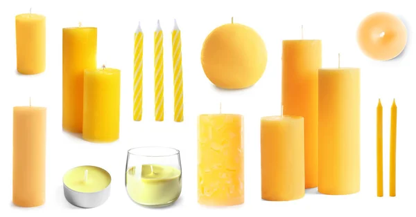Set avec des bougies jaunes décoratives sur fond blanc — Photo