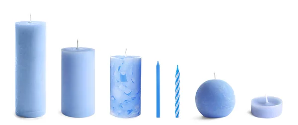 Комплект с различными голубыми свечами на белом фоне — стоковое фото