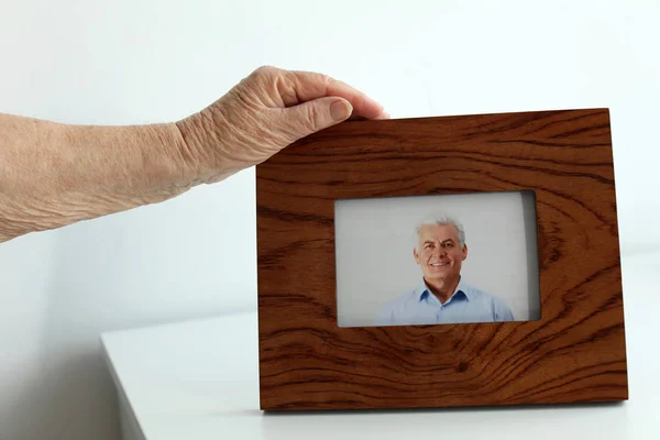 Oğlunun kapalı çerçeveli fotoğrafı ile yaşlı kadın, closeup — Stok fotoğraf