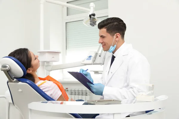 Dentista profissional que trabalha com paciente na clínica — Fotografia de Stock