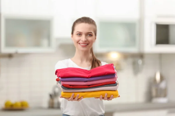女人在厨房里拿着折叠的干净的衣服。洗衣日 — 图库照片