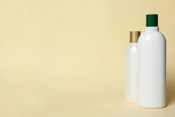 Bottles with cosmetic products on yellow background. Mockup for design