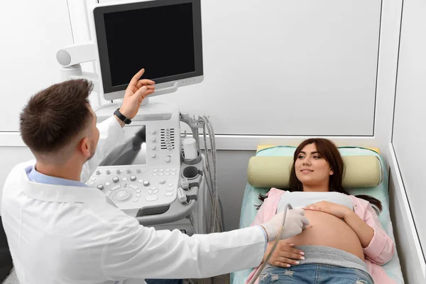 Junge Schwangere unterzieht sich in moderner Klinik einer Ultraschalluntersuchung — Stockfoto