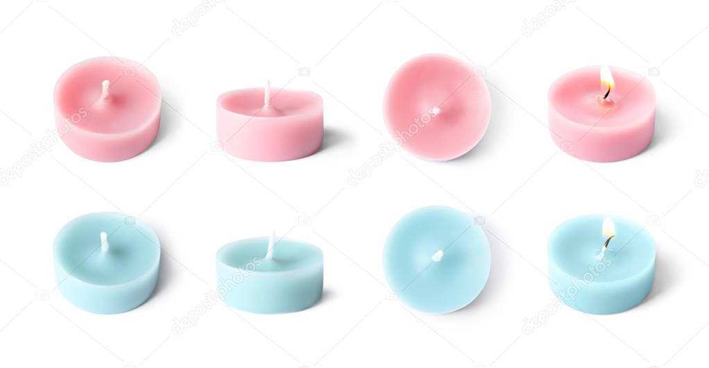 Set with different decorative wax candles on white background