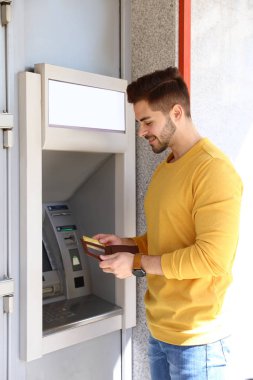 Modern nakit makinesi açık yakınında kredi kartı ile genç adam