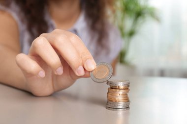 Genç kadın masada bozuk para istifleme, closeup