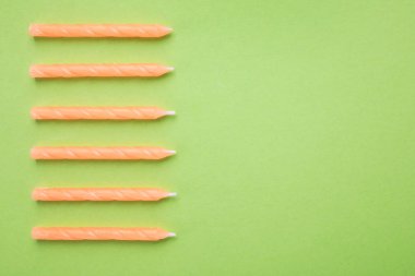 Yeşil arka planda turuncu doğum günü mumları, metin için alan ile üst görünüm