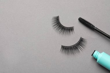 Gri arka planda yanlış kirpik ve maskara, düz yatıyordu. Metin alanı