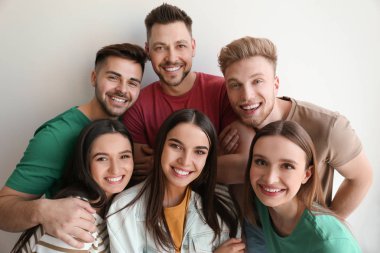 Işık duvarının yakınında poz veren bir grup mutlu insan