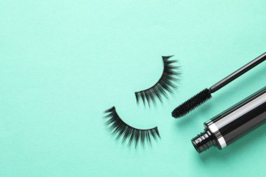 Turkuaz arka plan üzerinde sahte kirpik ve maskara, düz yatıyordu. Metin için alan