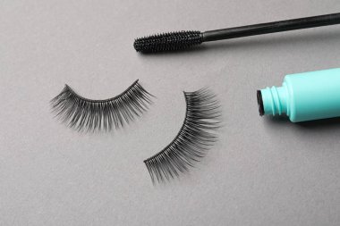 Gri arka planda sahte kirpik ler ve maskara