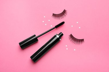 Pembe arka plan üzerinde yanlış kirpik ve maskara, düz yatıyordu