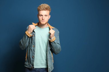 Mavi arka planda boş t-shirt giyen genç adam. Tasarım için mockup