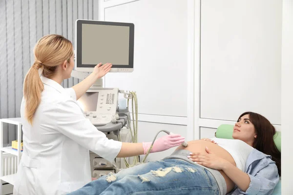 Młoda kobieta w ciąży poddawanych skanowaniu ultradźwięków w nowoczesnej klinice — Zdjęcie stockowe