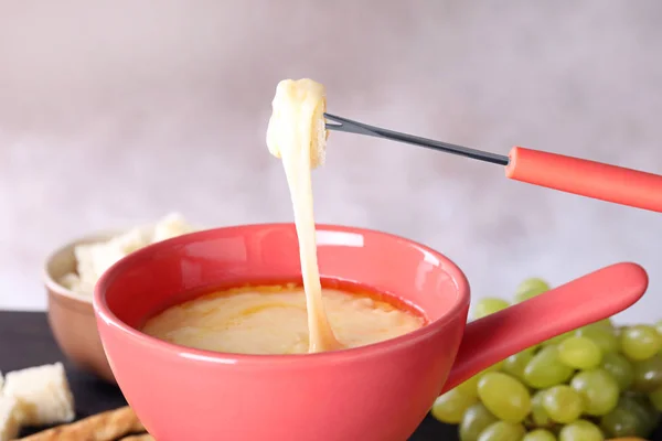 Doppa brödet i potten med ostfondue, närbild — Stockfoto