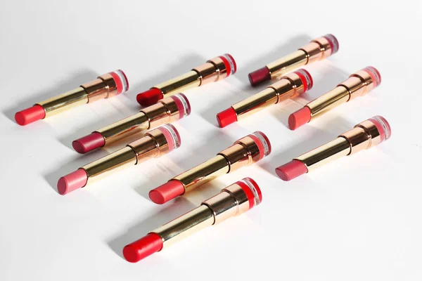 Set of bright lipsticks in gold tubes on white background — Stock Photo, Image