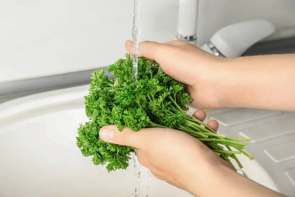 Wanita mencuci peterseli segar di bawah air keran di wastafel dapur, closeup — Stok Foto