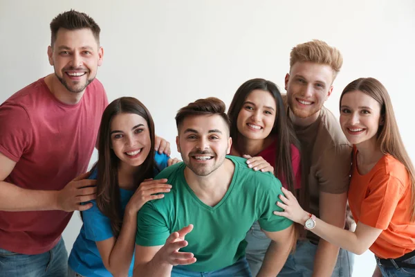 Gruppe glücklicher Menschen posiert in der Nähe einer Lichtwand — Stockfoto