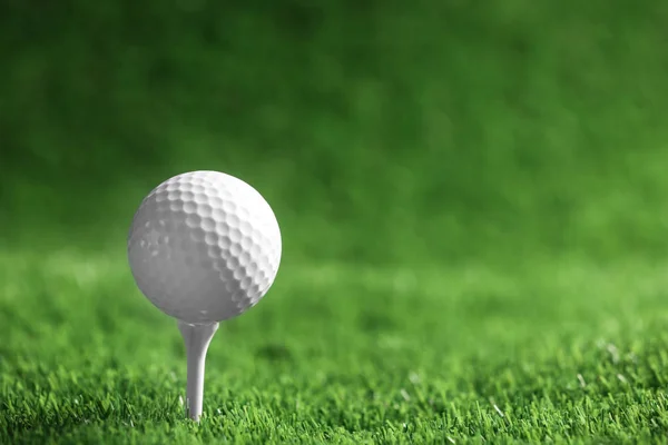 Piłka golfowa z tee na sztucznej trawie, miejsce na tekst — Zdjęcie stockowe