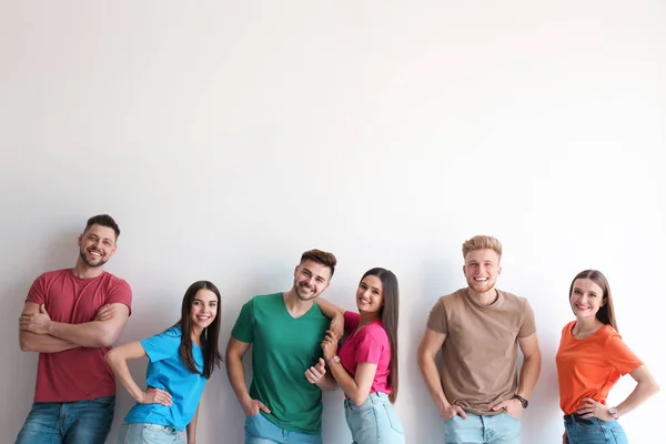 Gruppe glücklicher Menschen posiert in der Nähe einer Lichtwand, Raum für Text — Stockfoto