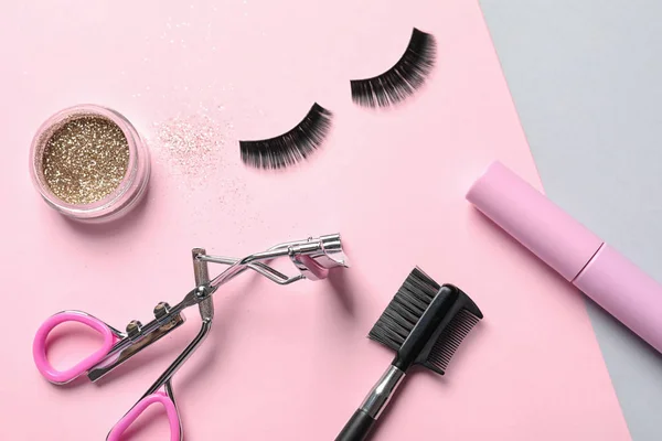 Platte lay compositie met valse wimpers en andere make-up producten op kleur achtergrond — Stockfoto