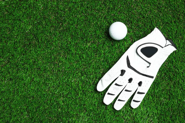 Golfbal en handschoen op kunstgras, bovenaanzicht met ruimte voor tekst — Stockfoto