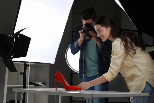 Professional photographers shooting stylish shoes in studio
