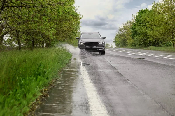 Våt förorts väg med bil på regnig dag — Stockfoto