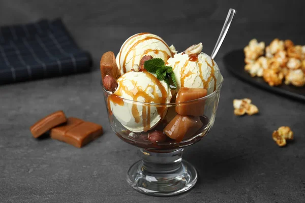 Вкусное мороженое с карамелью и соусом подается на стол — стоковое фото