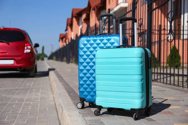 Kolorowe walizki i samochód rodzinny w mieście. Wakacje — Zdjęcie stockowe