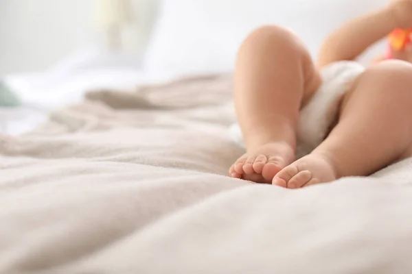Lindo bebé tendido en la cama, primer plano de las piernas. Espacio para texto —  Fotos de Stock