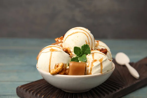 Вкусное мороженое с карамелью, попкорном и соусом подается на столе — стоковое фото