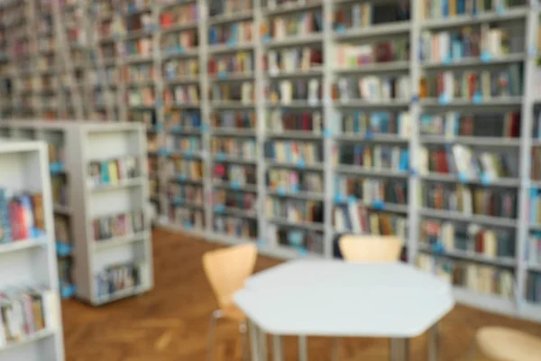 Vista borrosa de las estanterías y la mesa en la biblioteca —  Fotos de Stock