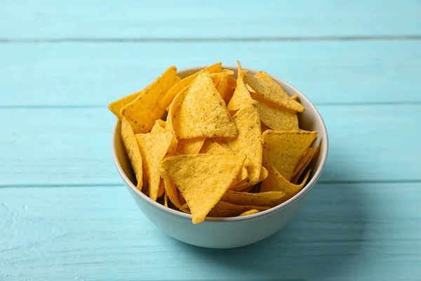 Smakelijke Mexicaanse nacho's chips in Bowl op blauwe houten tafel — Stockfoto