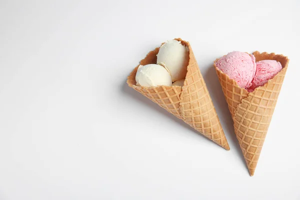 Deliciosos sorvetes em cones de bolacha no fundo branco, vista superior — Fotografia de Stock