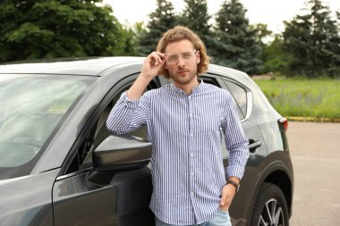 Çekici genç adam yakın lüks araba açık havada