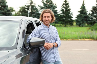 Çekici genç adam yakın lüks araba açık havada