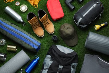 Yeşil çim üzerinde farklı kamp ekipmanları ile Düz yatıyordu kompozisyon