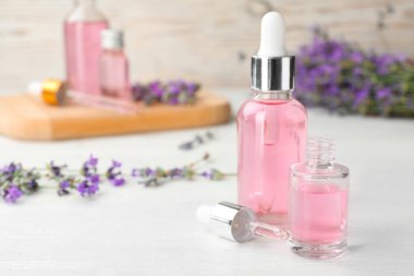 Beyaz ahşap masa üzerinde doğal lavanta uçucu yağ ile Şişeler. Metin için alan