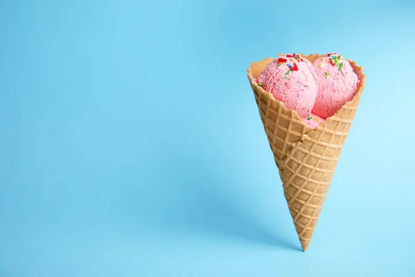 Вкусное мороженое в вафельном конусе на синем фоне. Пространство для текста — стоковое фото
