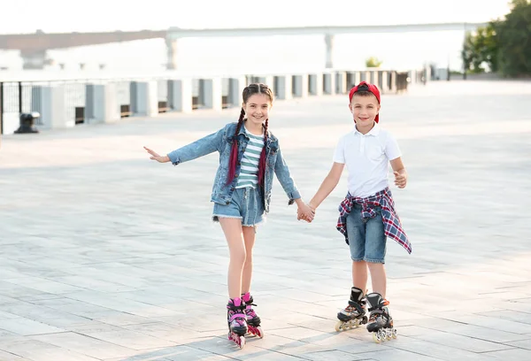 Niños pequeños patinando en la calle de la ciudad — Foto de Stock