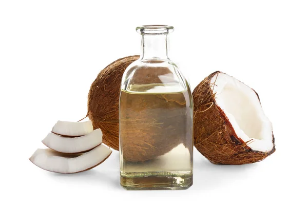Cocos maduros e garrafa com óleo orgânico natural sobre fundo branco — Fotografia de Stock