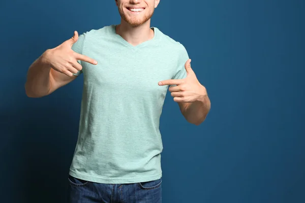 Молодий чоловік у порожній футболці на синьому фоні, крупним планом. Макет для дизайну — стокове фото