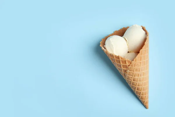 Köstliches Vanilleeis in Waffelkegel auf blauem Hintergrund, Draufsicht. Raum für Text — Stockfoto