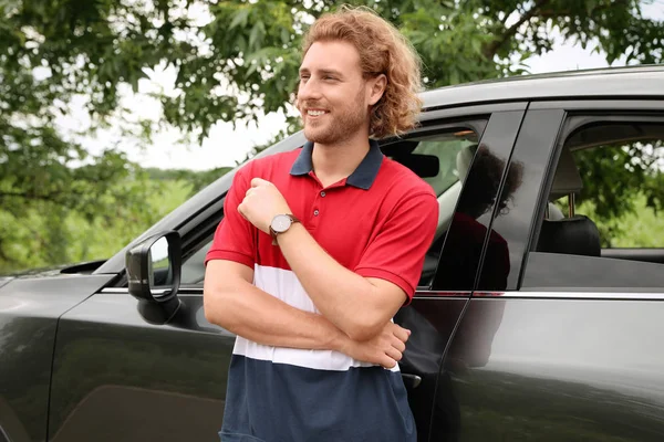 Çekici genç adam yakın lüks araba açık havada